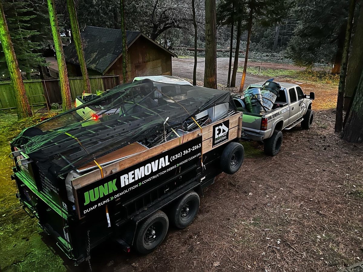 Loaded dump trailer with secured junk on a forest property job